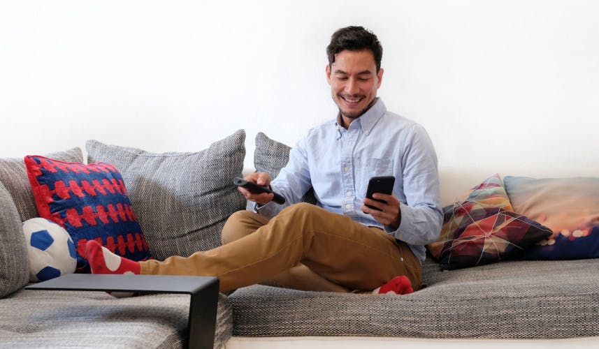 man on sofa on his phone