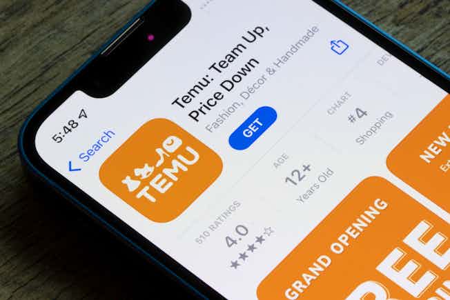 A phone screen showing the old app listing for Temu that displays its previous slogan of: Team Up, Price Down.